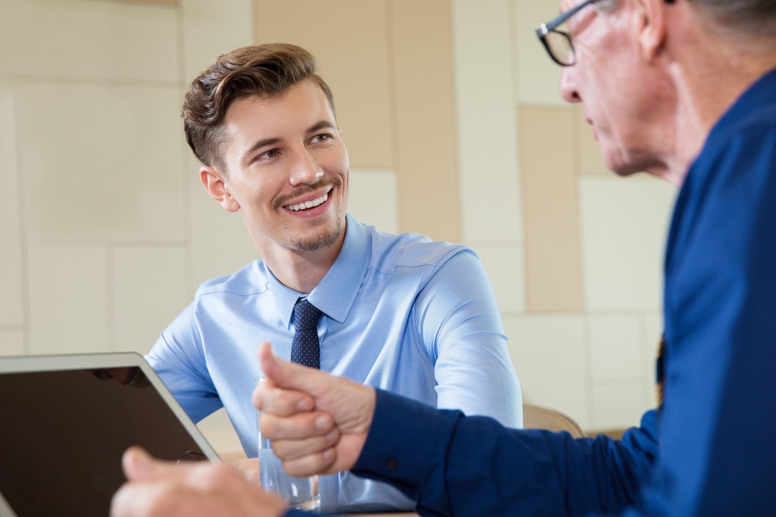 smiling businessman listening senior man scaled